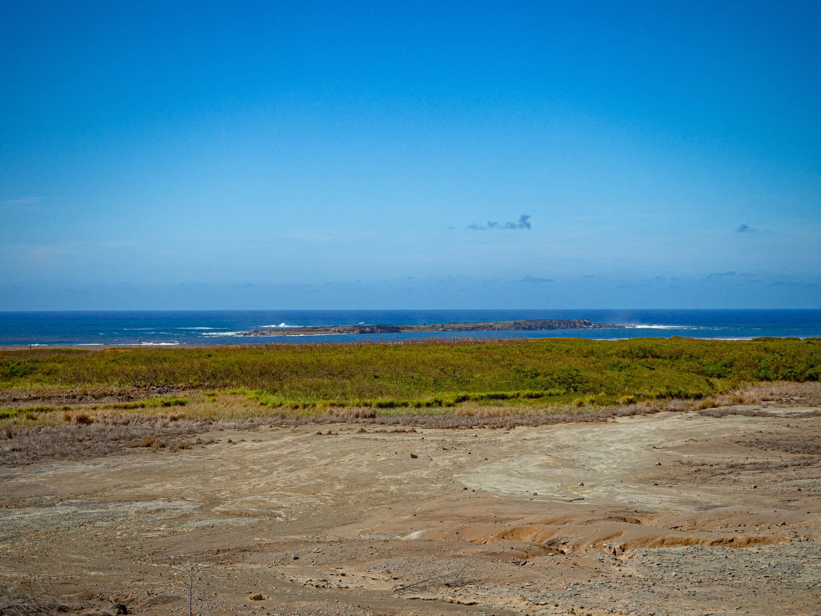 硫黄島の鶯地獄から監獄岩を望む青い海と荒涼とした大地の風景