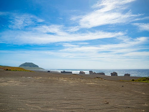 千鳥ヶ浜（西海岸）の沈船群と奥に霞む摺鉢山の写真