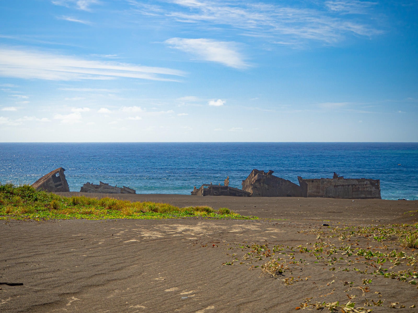 硫黄島の海岸に現れた戦後米軍のコンクリート沈船群と青空