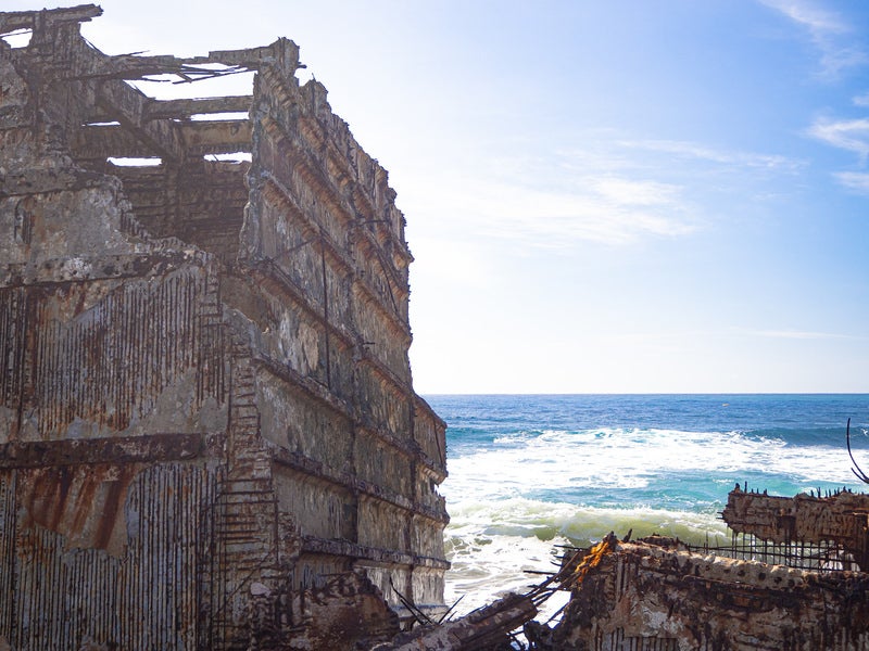 ボロボロになり骨組みの鉄筋が露わになったコンクリート船の残骸