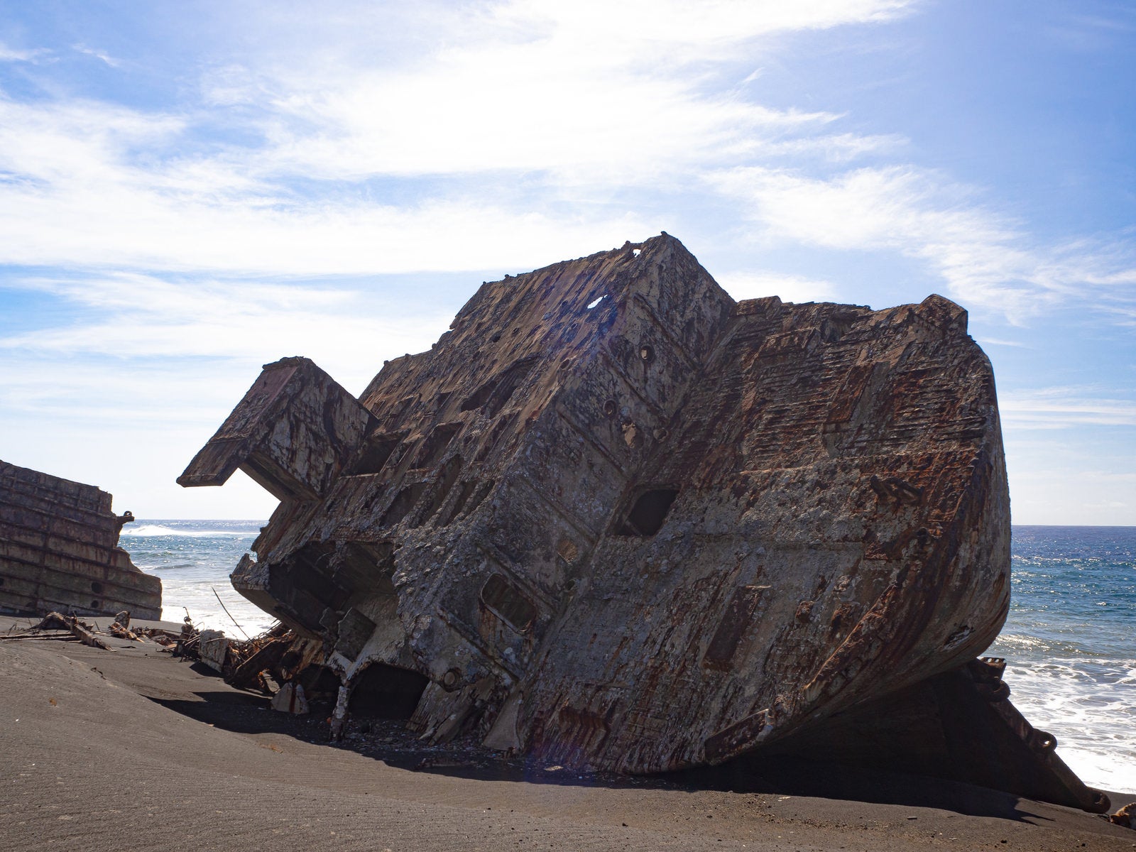 「ボロボロに朽ちて千鳥ヶ浜に横たわる海底の隆起によって姿を現した船の残骸」の写真