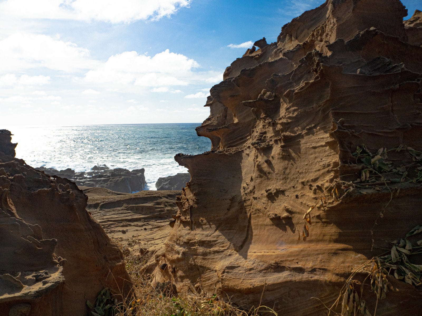 「釜岩の奇石の合間から見える輝く海」の写真