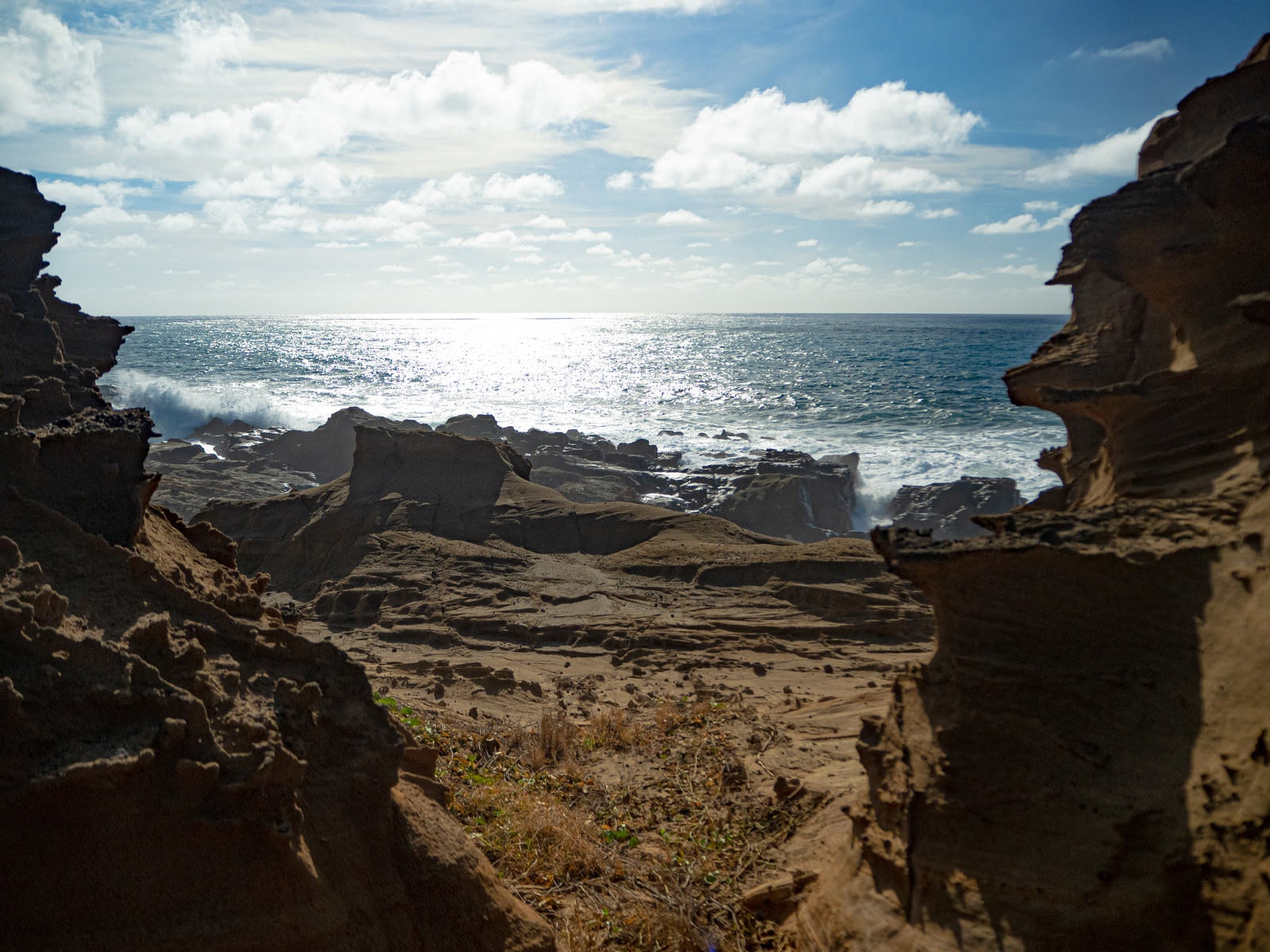 「激しく寄せる波の飛沫でかすむ釜岩の波打ち際」の写真