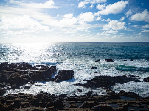 硫黄島・釜岩から見る光る海と寄せて砕ける波の写真