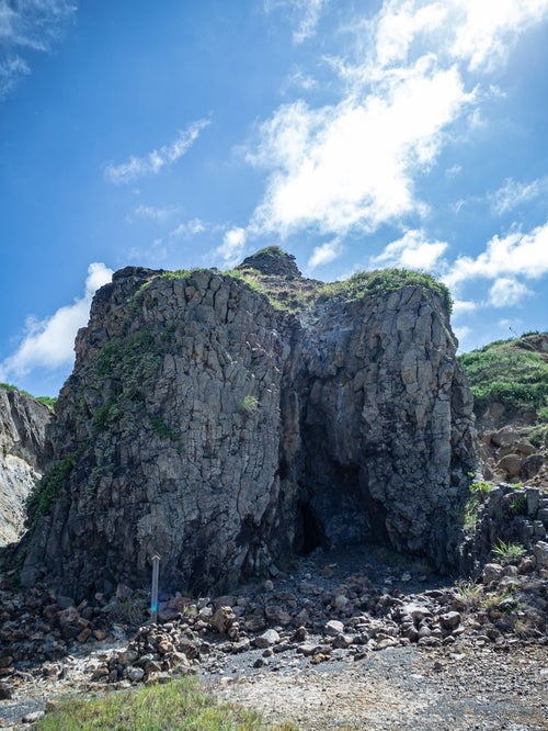 硫黄島唯一の真水が溜まる高さ１０メートルほどの柱状節理が集まった大きな岩山の写真
