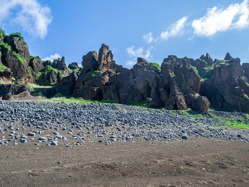 北の鼻の断崖とその足元に広がる石積の写真