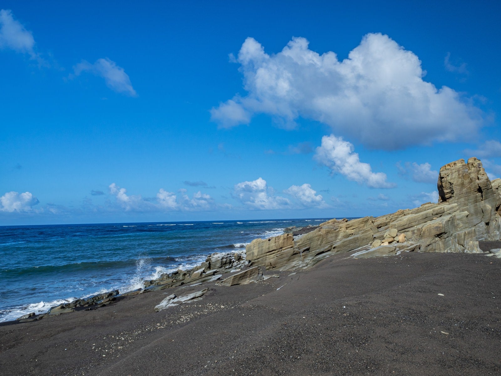 「海に向かって傾斜する北の鼻の海岸の岩場」の写真