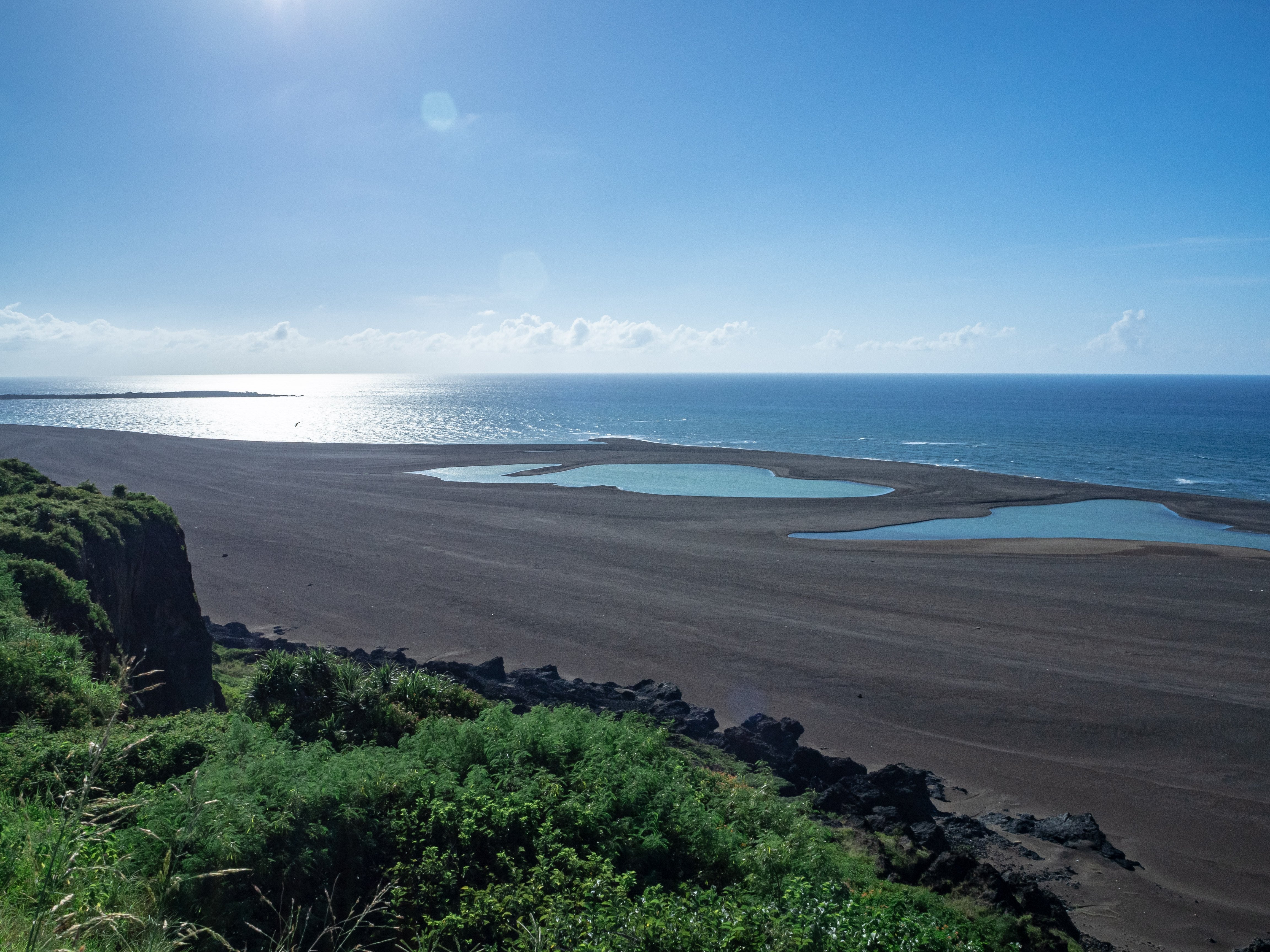 輝く海とここ一年の隆起で取り残された為八海岸の水たまりの無料の写真