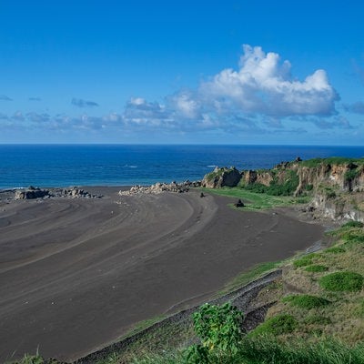 度重なる隆起でできた砂浜の年輪のような海岸線の跡の写真