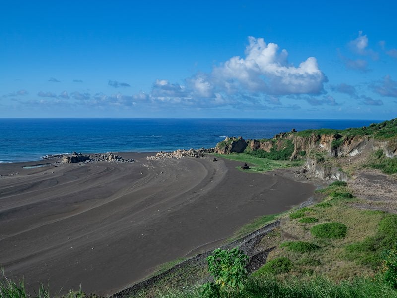 度重なる隆起でできた砂浜の年輪のような海岸線の跡の写真