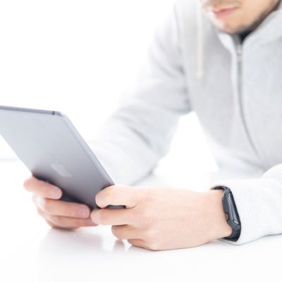 iPadminiで読書する男性の写真