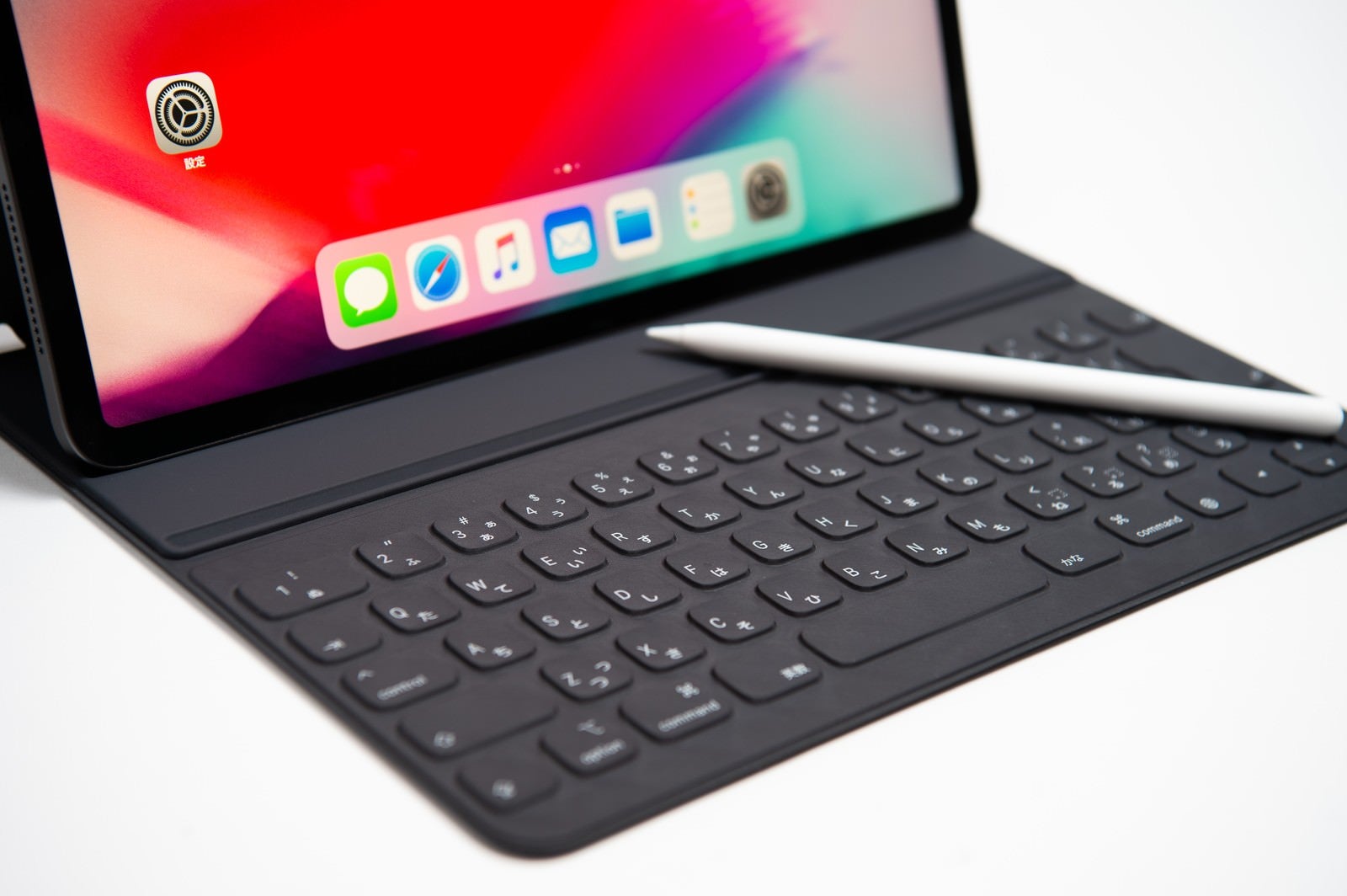 「iPad に接続した Smart Keyboard Folioのキーボードに転がるApple pencil」の写真