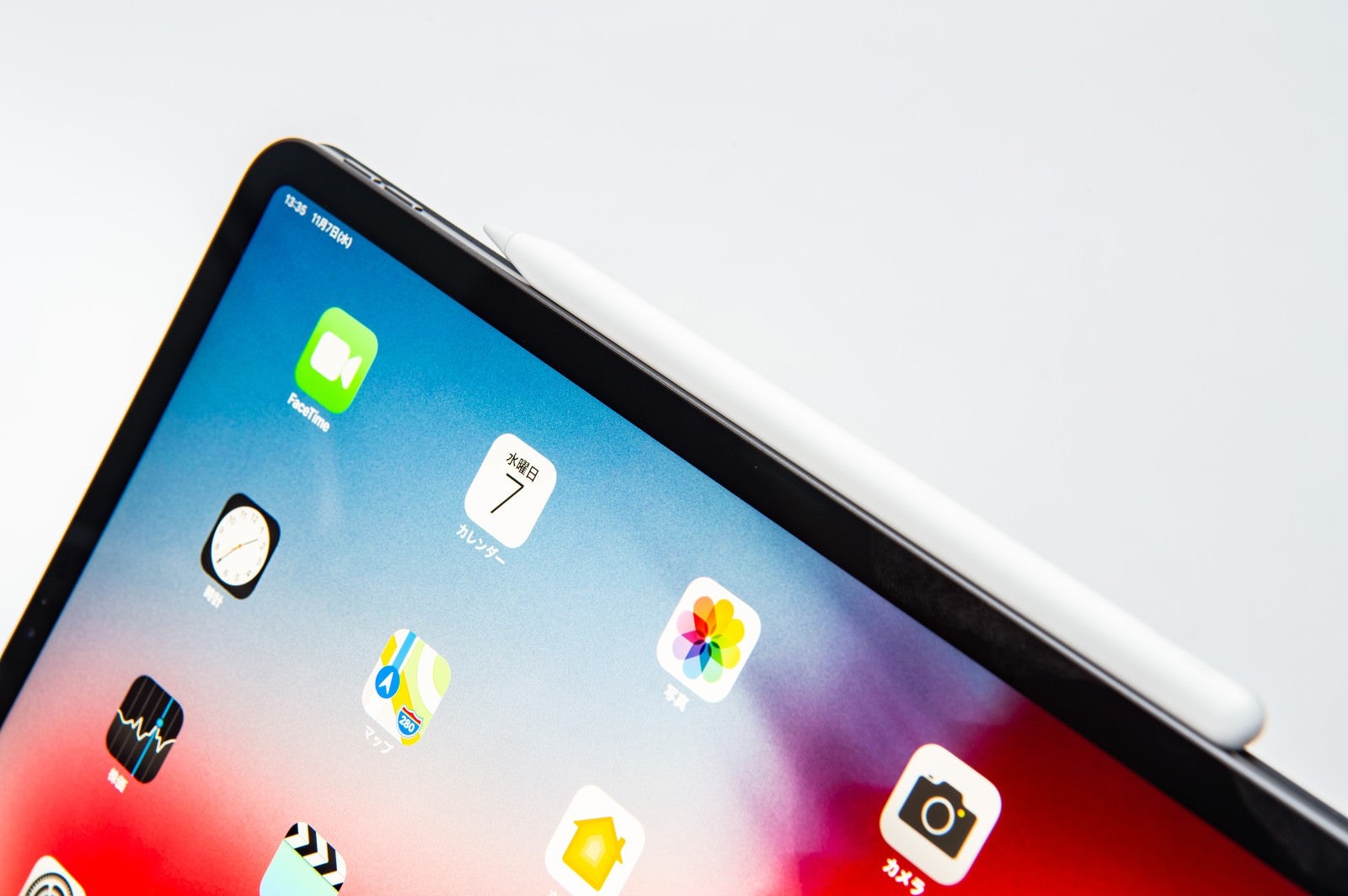 「タブレット側面に装着されたApple pencilとホーム画面（iPad Pro 2018）」の写真