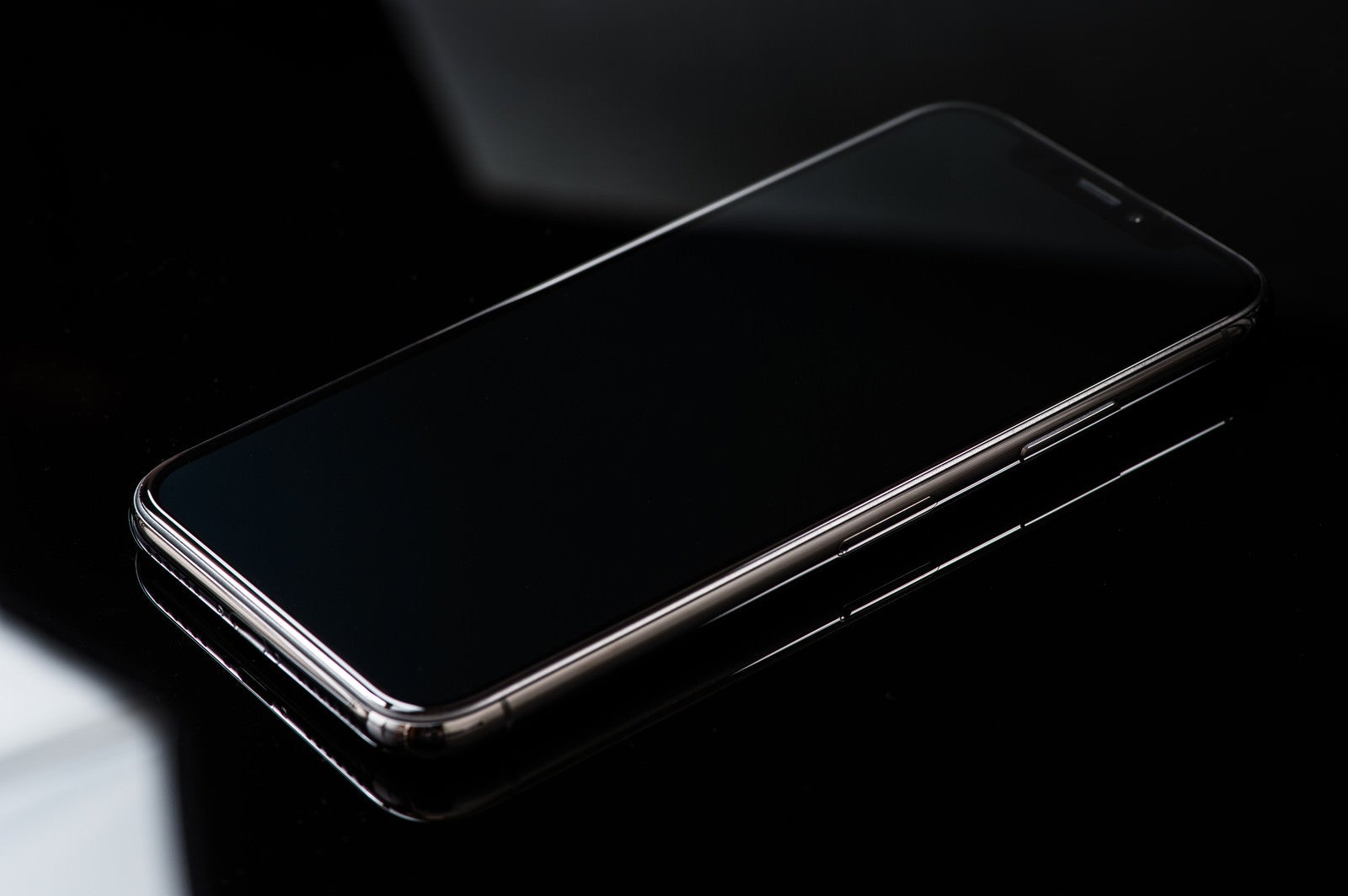 「iPhone X と映り込む照明の光」の写真