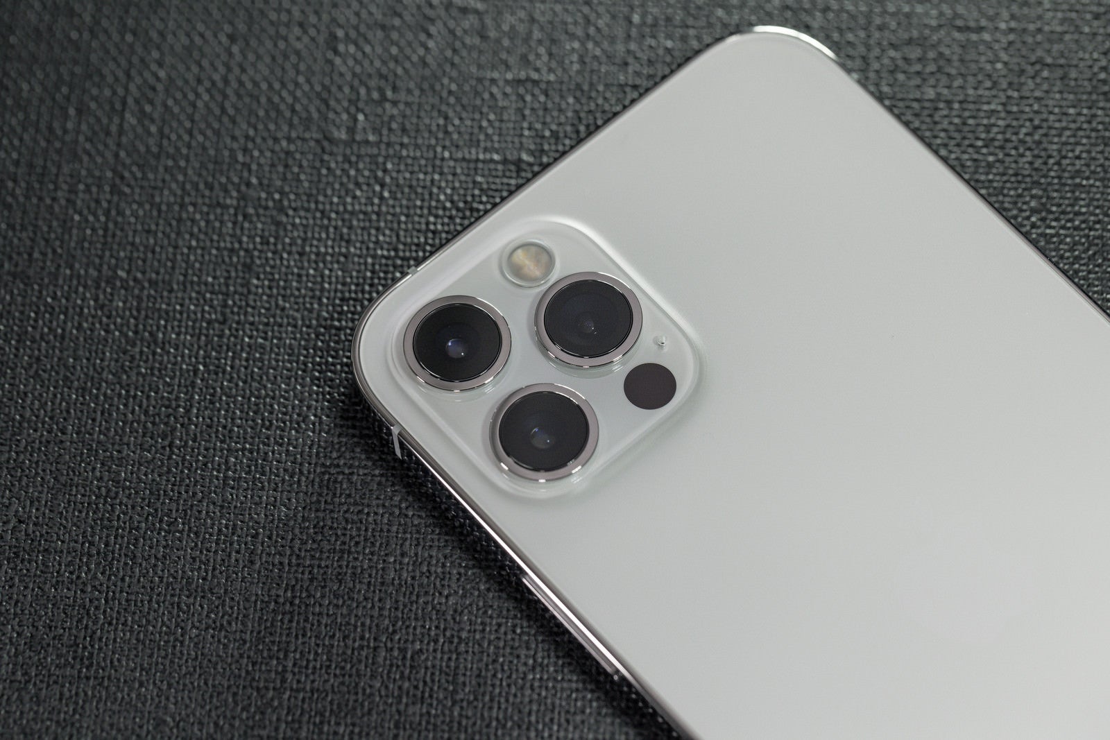 「3眼カメラと背面ホワイトの iPhone 12 pro」の写真