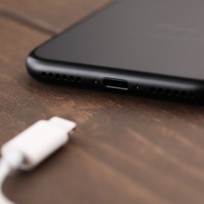 薄型のスマートフォンと充電コネクタの写真