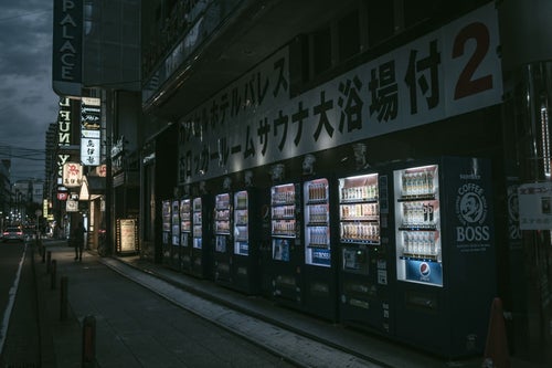 ズラリと歩道に並ぶ自動販売機の写真