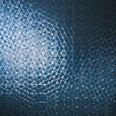 光が反射する幾何学模様のガラス窓（テクスチャ）の写真