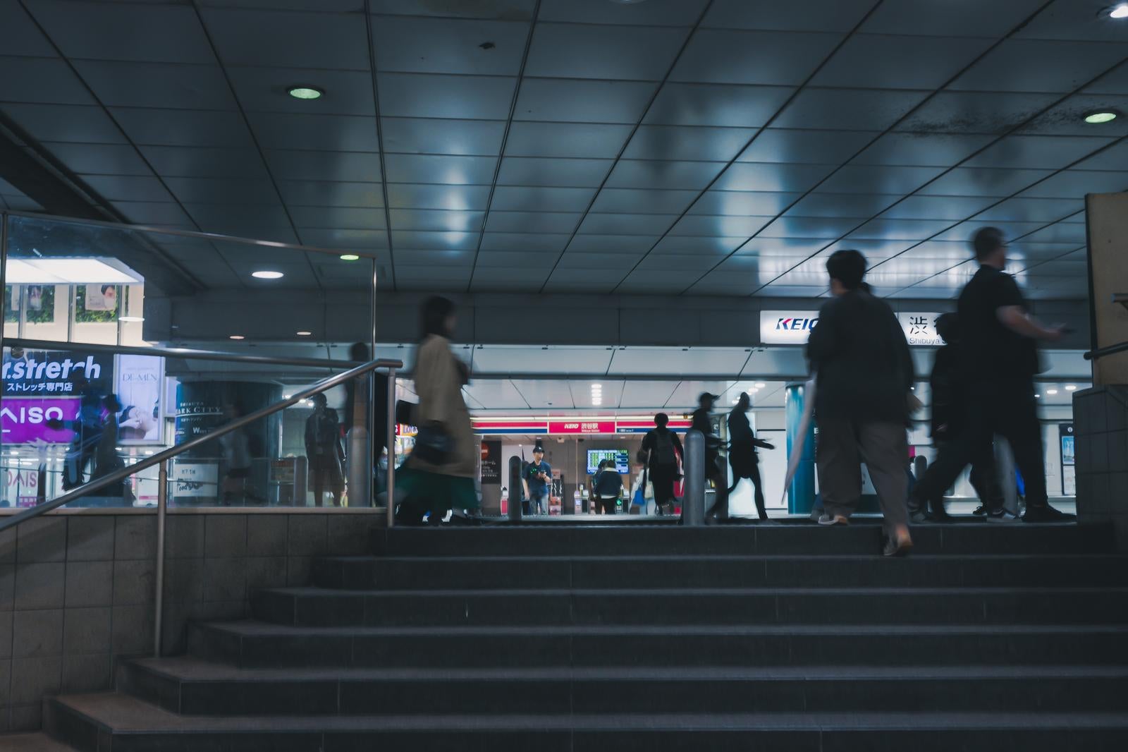 「渋谷駅地下通路の賑わいと京王線の看板」の写真