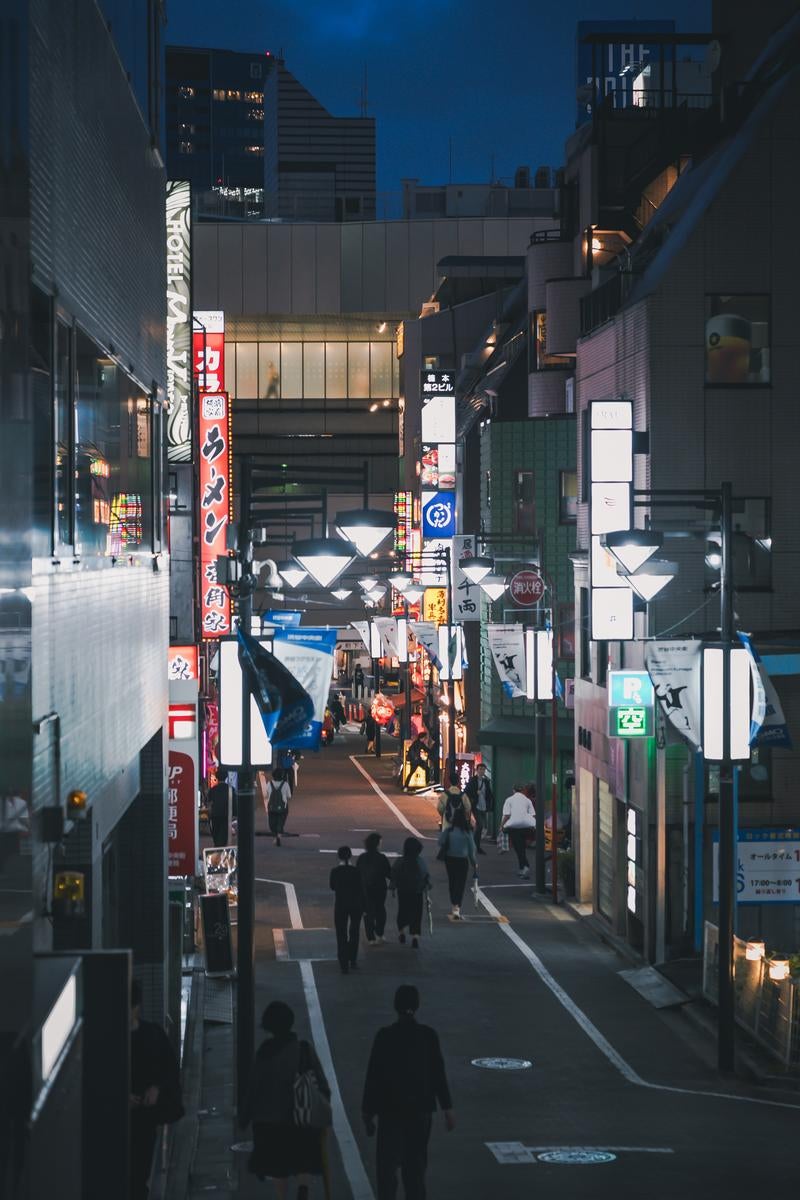 夜のセルリアンタワー通りのネオンと人々が行き交う東京の夜の写真