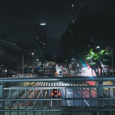 渋谷駅13番出口前の夜景と歩道橋上から見た明治通りの光景の写真