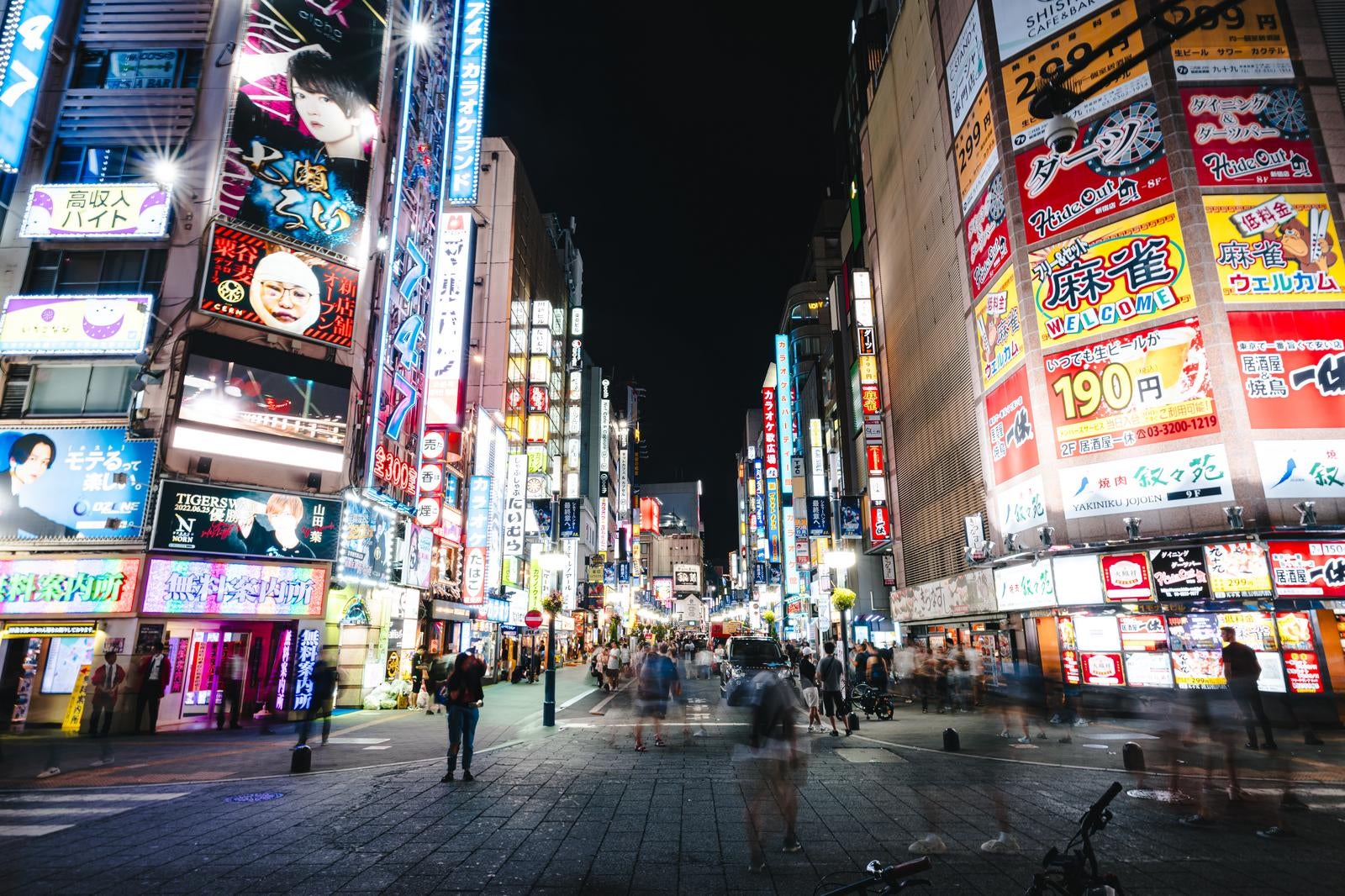 「人であふれる新宿歌舞伎町TOHOシネマズ前のセントラルロード（夜間）」の写真