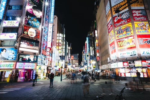 人であふれる新宿歌舞伎町TOHOシネマズ前のセントラルロード（夜間）の写真