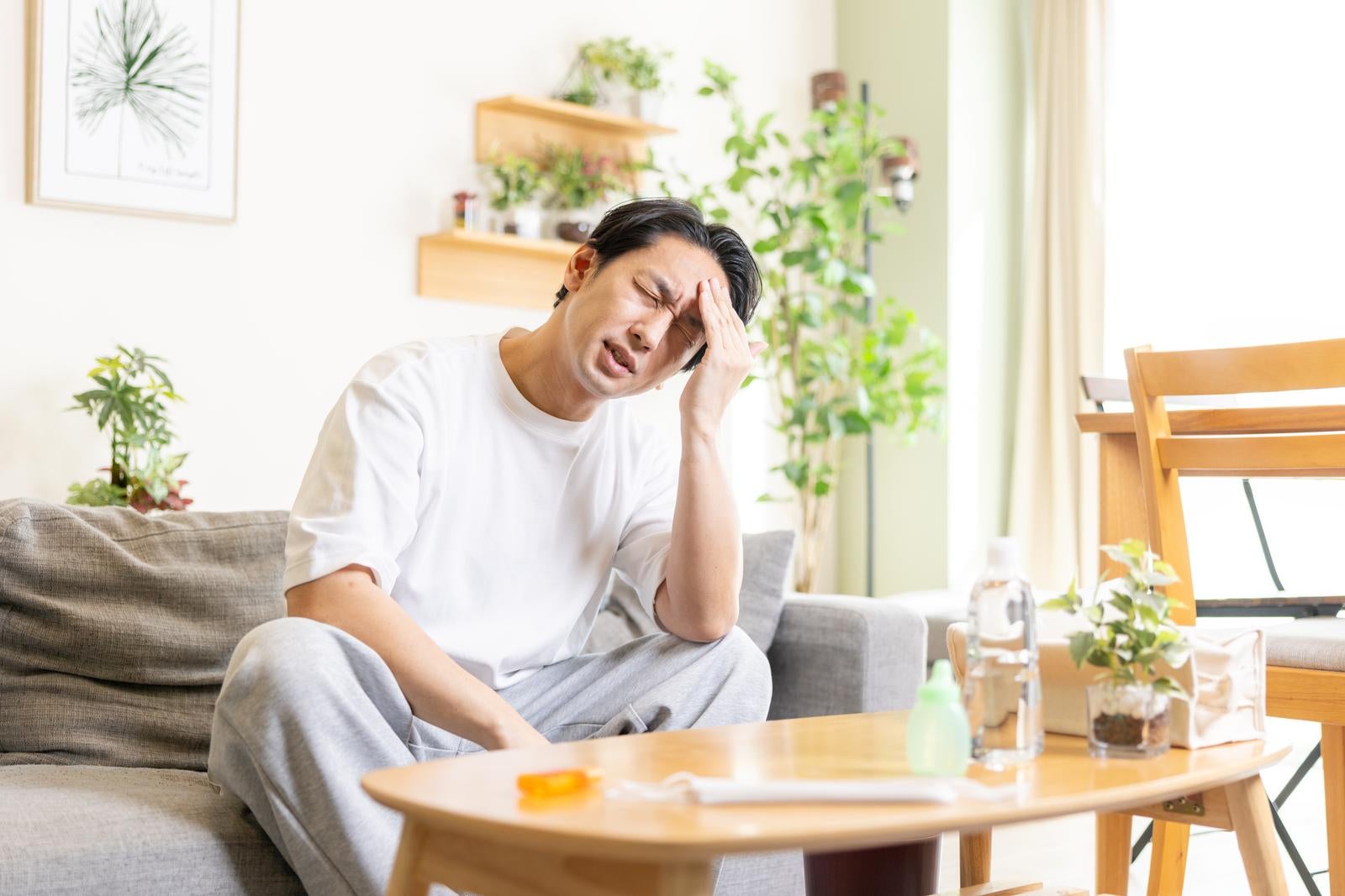 「つらい頭痛で頭が割れそうな男性」の写真［モデル：大川竜弥］