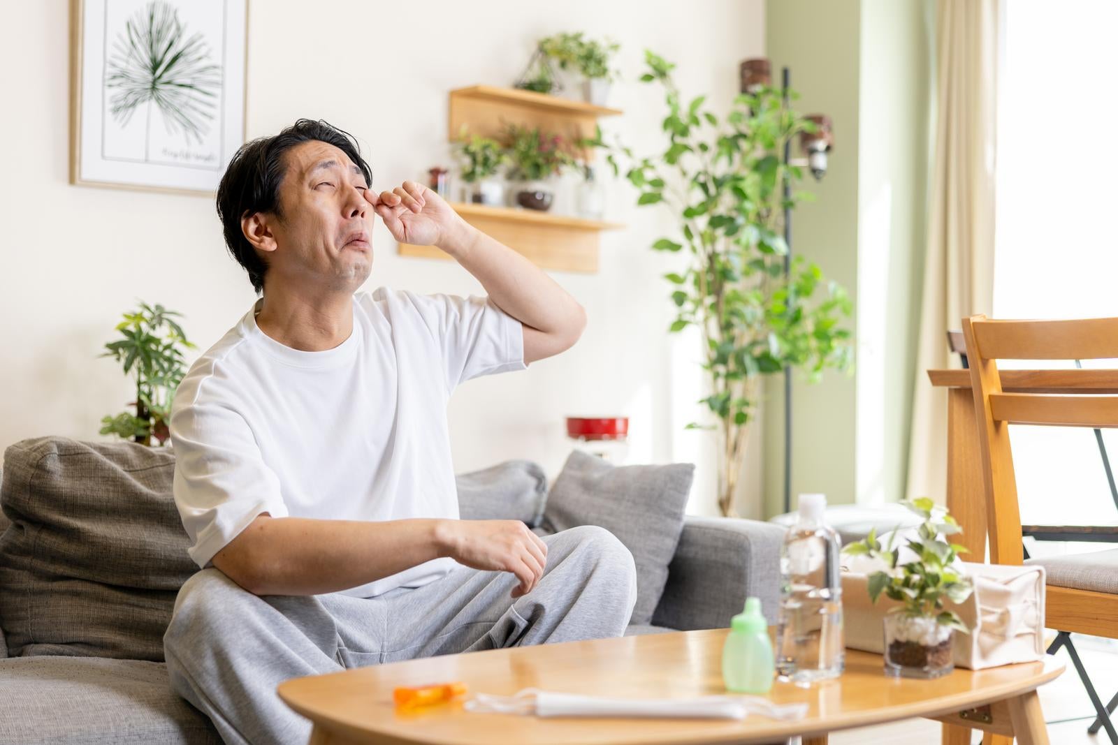 「花粉症によって目のかゆみが止まらない男性」の写真［モデル：大川竜弥］