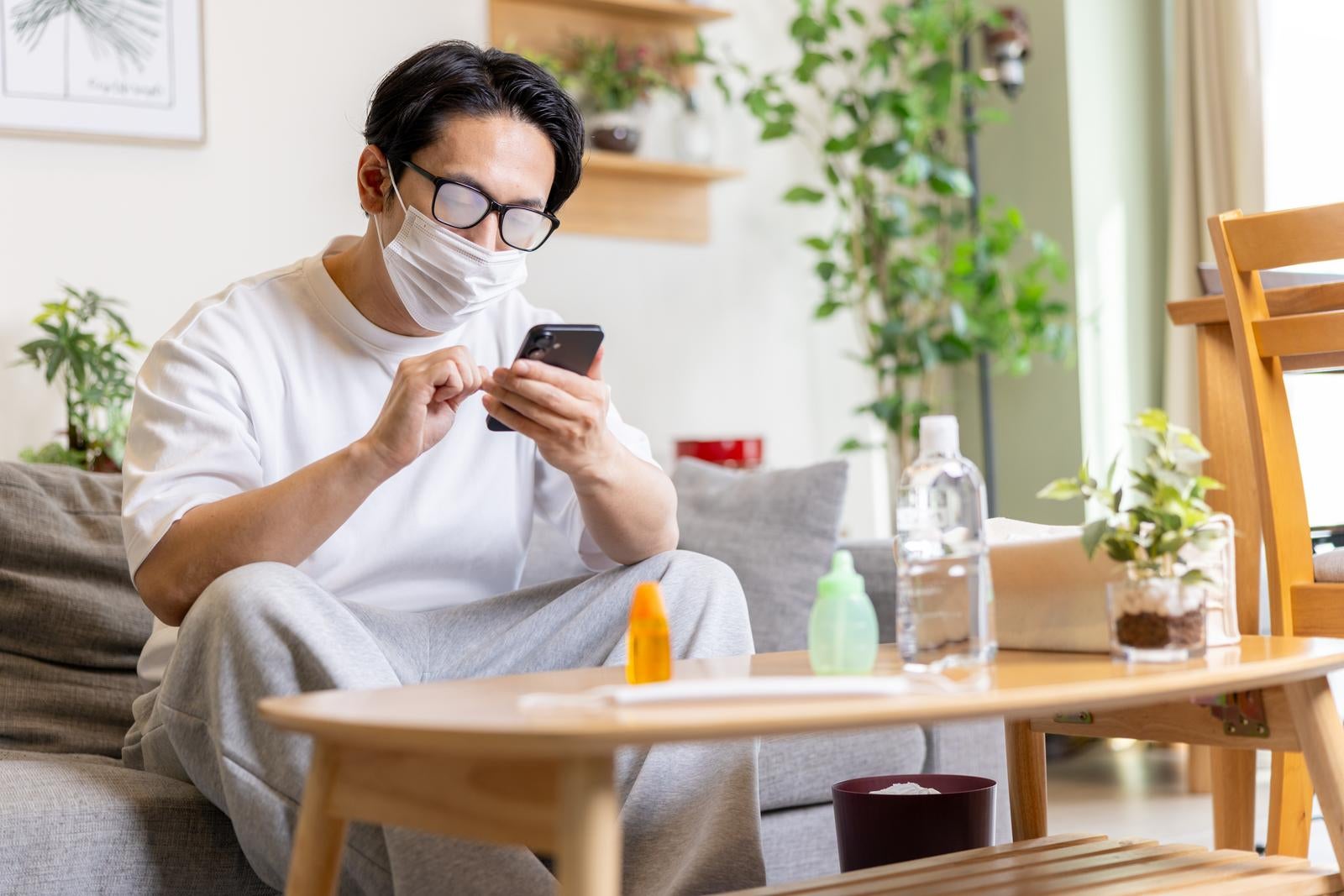 「マスクが曇りすぎてスマホが見えない男性」の写真［モデル：大川竜弥］