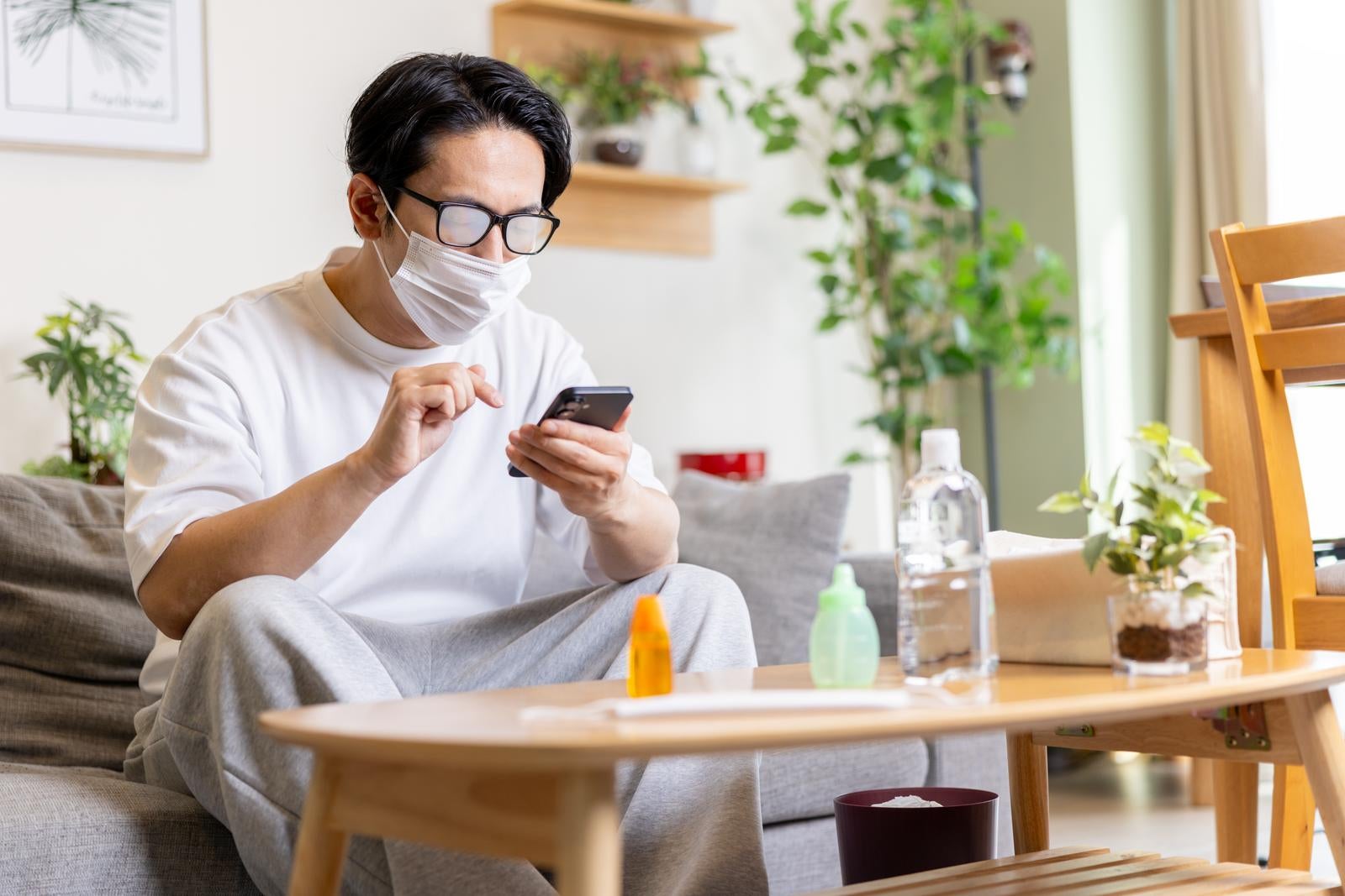 「眼鏡が曇ってもスマホをやり続ける男性」の写真［モデル：大川竜弥］