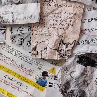 散乱した手書きメモと新聞紙の写真