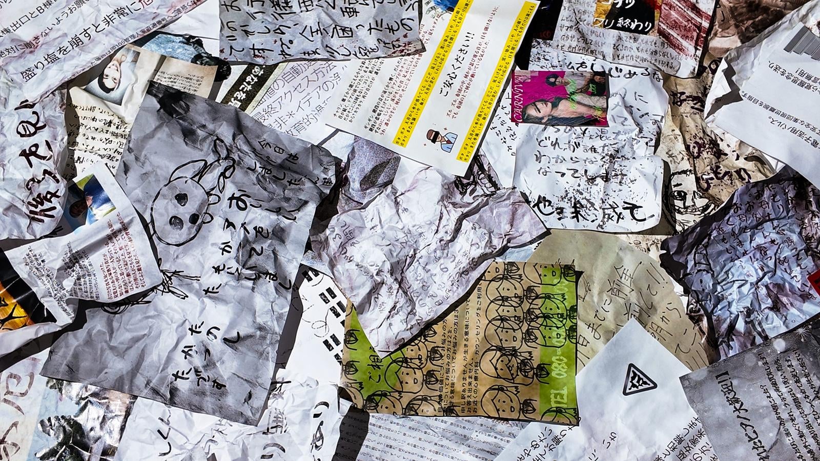 しわしわになった手書きメモや紙くずが散らかっている状態