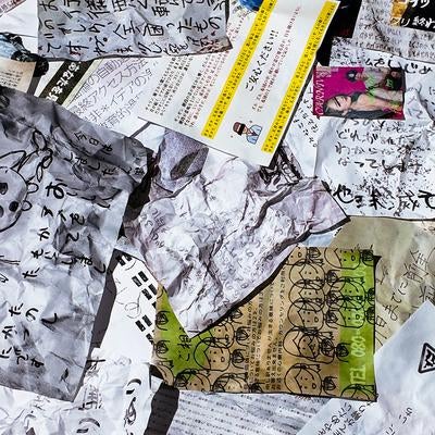 散らかった紙くずと手書きメモの写真