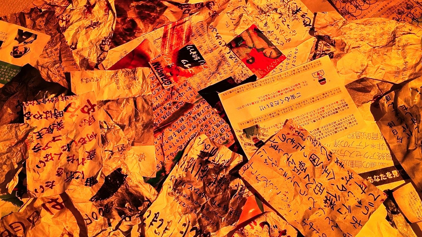 「オレンジ照明で照らされた怪文書の山」の写真