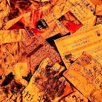 オレンジ照明で照らされた怪文書の山の写真