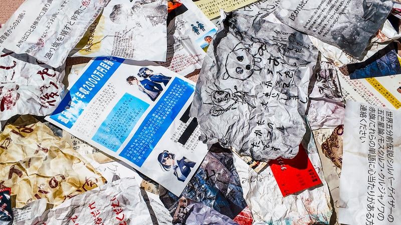 床一面に散らばった怪文書と雑誌が無造作に重なり合うの写真