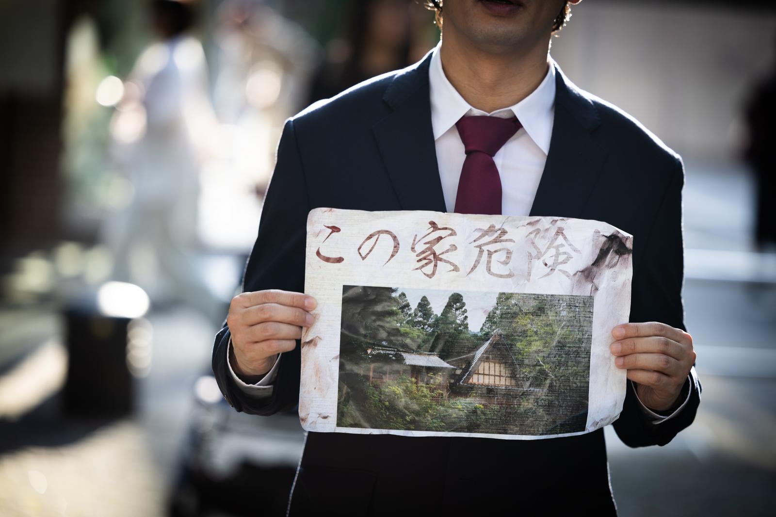 「不安を煽る危険警告と正体不明の男」の写真［モデル：大川竜弥］