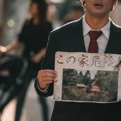 問題物件の怪文書を持つひとの写真