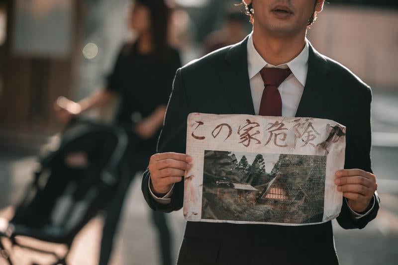 問題物件の怪文書を持つひとの写真