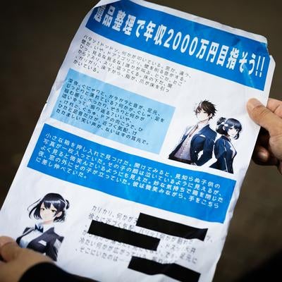 怪しすぎる高収入勧誘チラシを持つ人物の写真