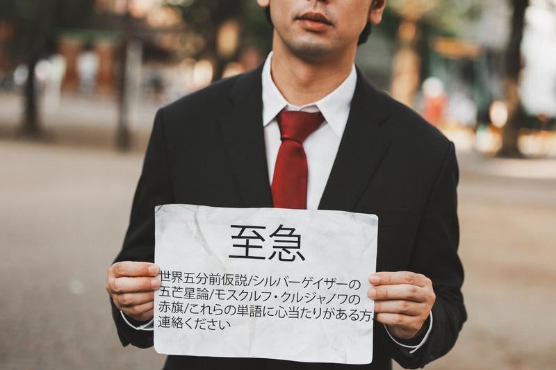 不穏な緊急警告文を持つ謎の人物の写真