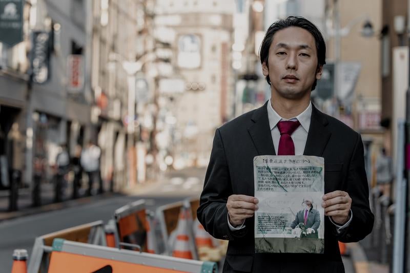 チラシを持って路上に立つだけの簡単なお仕事の写真