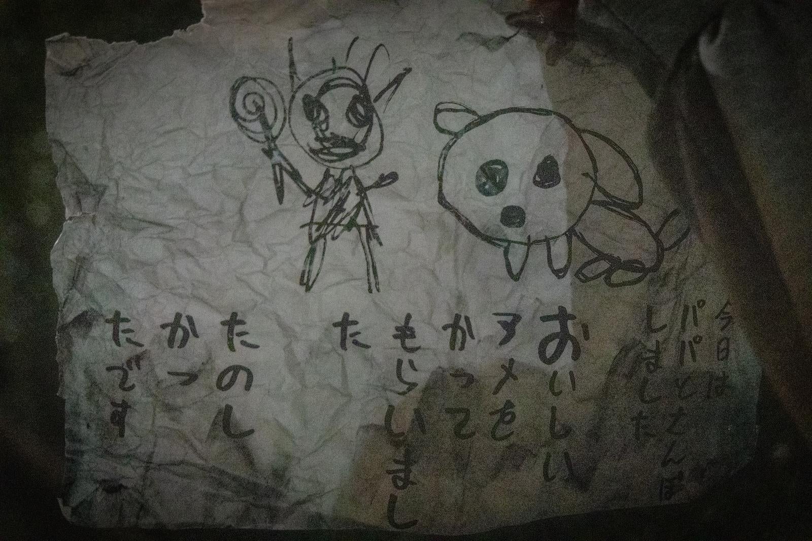 「不気味なイラストとメッセージが残る紙切れ」の写真