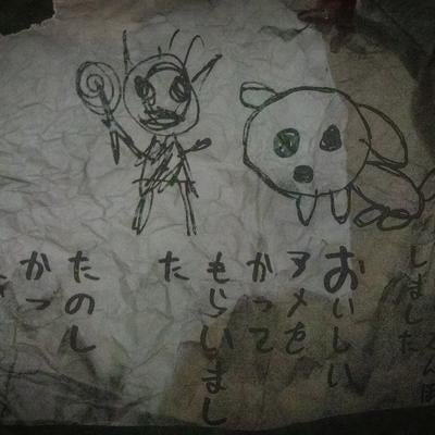 不気味なイラストとメッセージが残る紙切れの写真