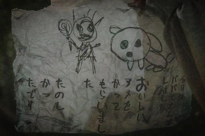 不気味なイラストとメッセージが残る紙切れの写真
