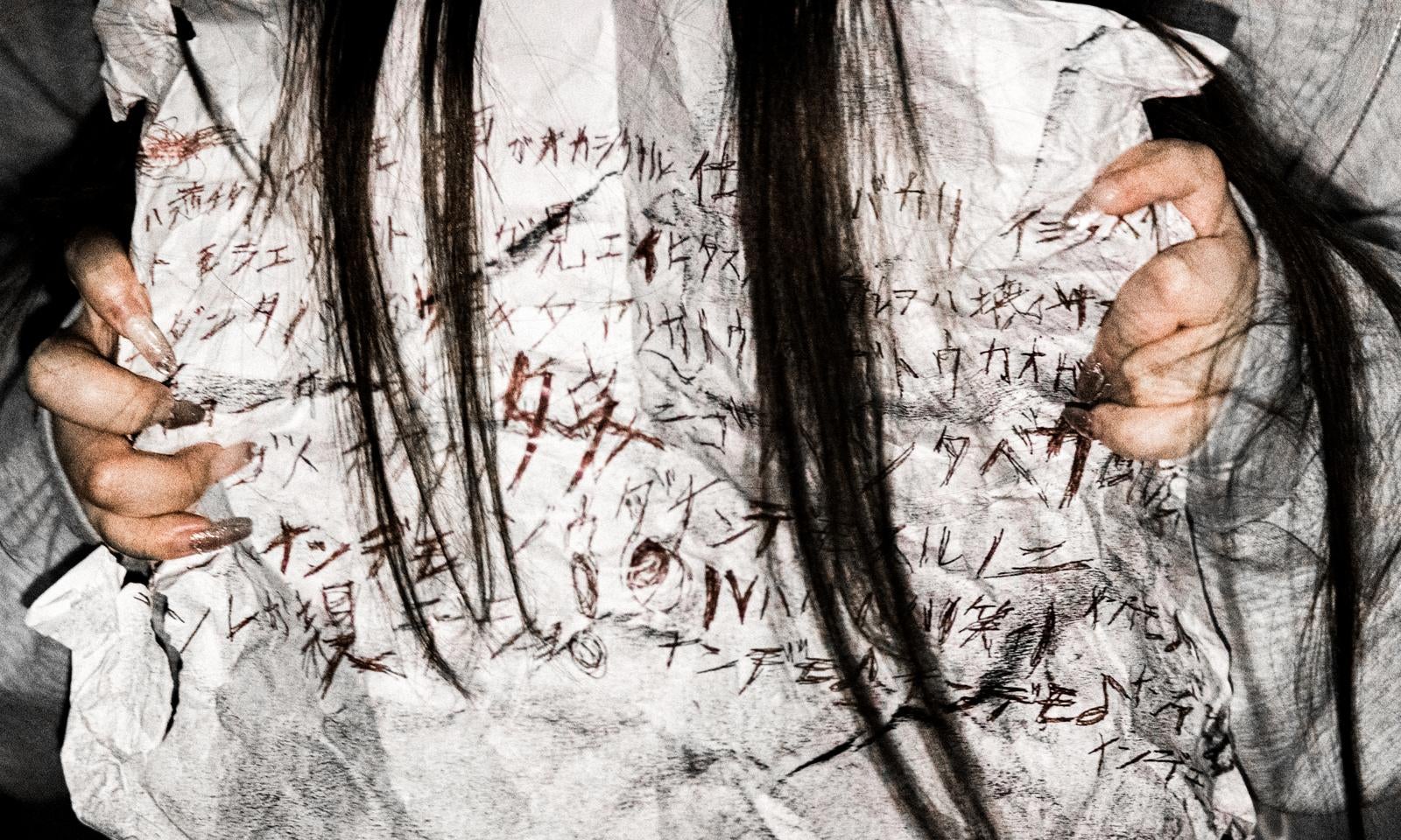 「怪文書を握りしめる長髪女性の恐怖」の写真