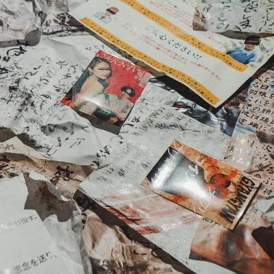 床に散乱した手書き文字のビラの写真