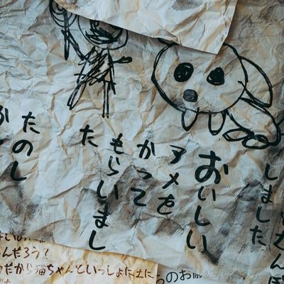 折り目と汚れが目立つ古い紙に手書きされた落書きの写真