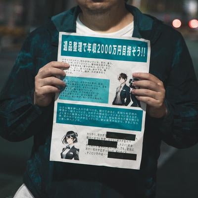 夜道で高収入勧誘の怪文書を掲げる人物の写真